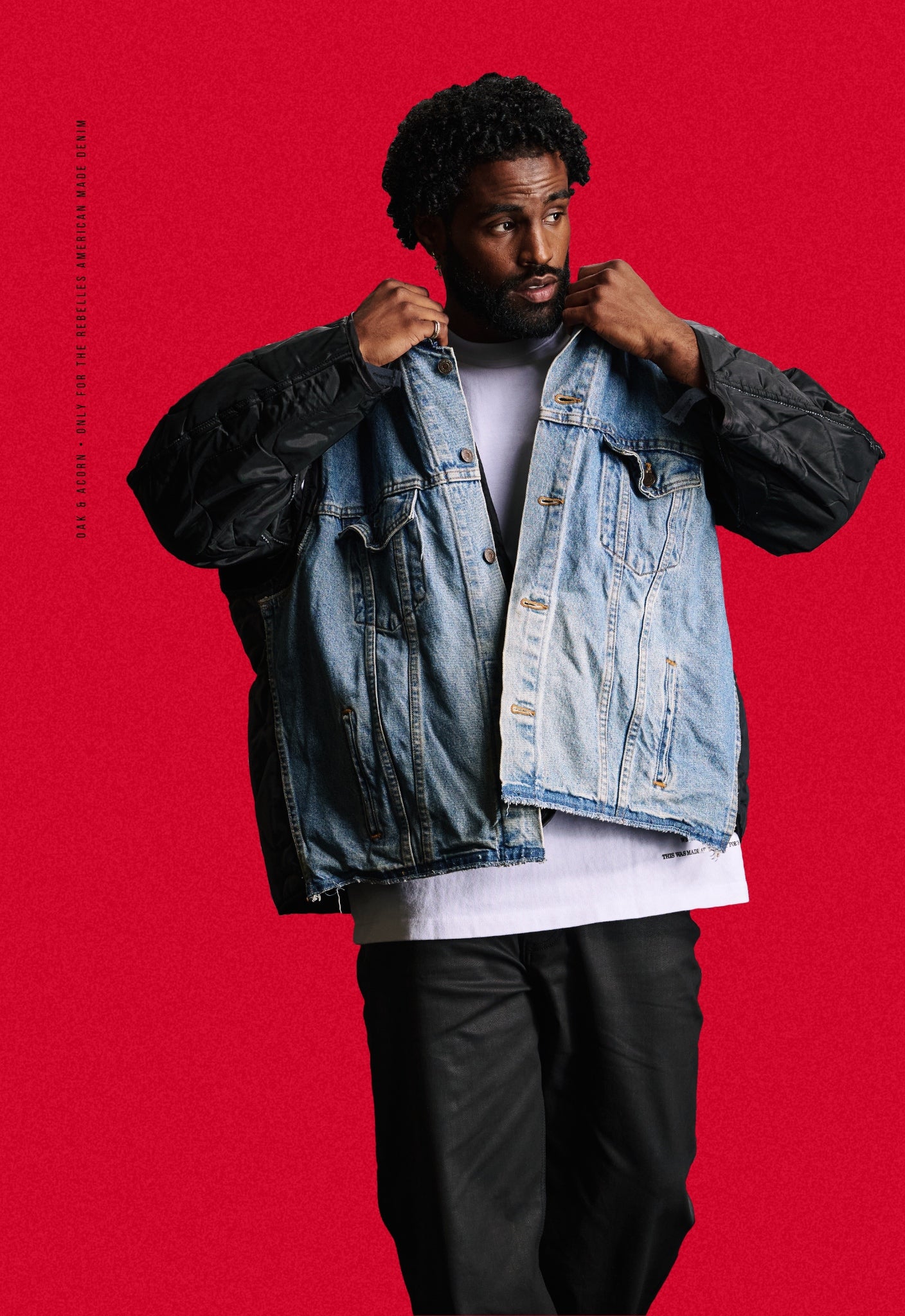Man wearing a black quilted repurposed denim jacket over a heavyweight white t-shirt on a red background